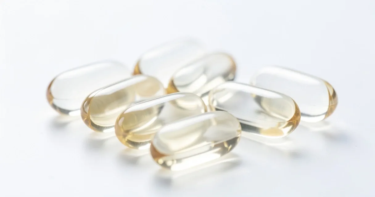 Natural supplement capsules on a clinical white surface